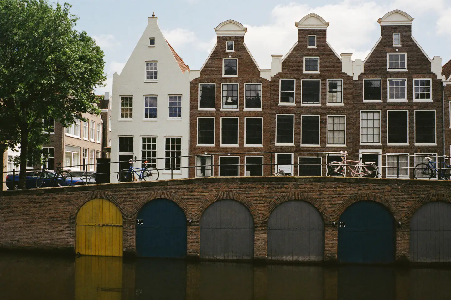 Gereinigde en opnieuw gevoegde bakstenen grachtenhuizen boven een verdiepte gracht met werfkelders